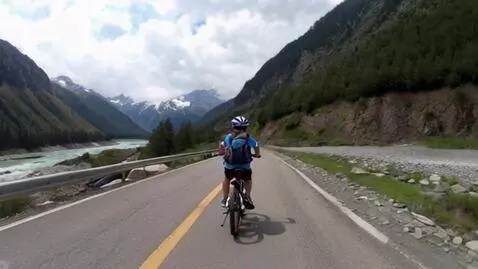 AI Video from prompt: Boy riding the bike in Himalayan mountains besid