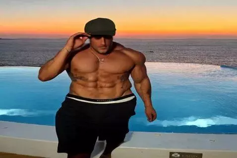AI Video from prompt: Film a shirtless, muscular man walking barefoot 