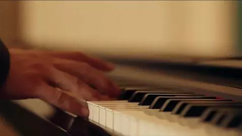 AI Video from prompt: Close-up shot of a piano. A musician slowly and 