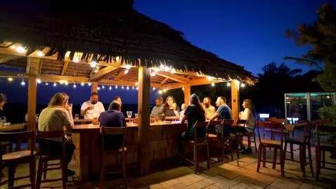 AI Video from prompt: People drinking at an outside bar at night