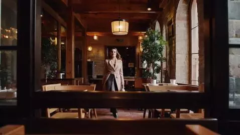 AI Video from prompt: "Well-dressed woman enters a cozy café, stylish 
