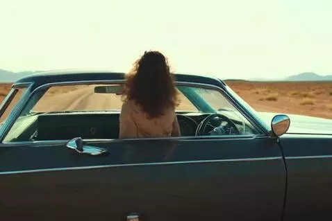 AI Video from prompt: Girl driving classic car through desert finds ca