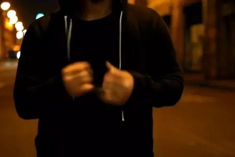 AI Video from prompt: A man stands center frame on a dimly lit urban s