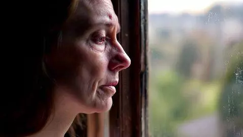 AI Video from prompt: A calm close-up shot of a woman sitting by the w