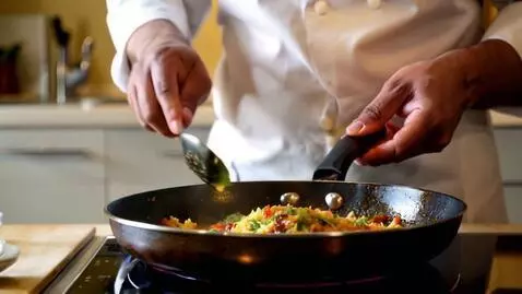 AI Video from prompt: Jollof rice and chicken preparation in a kitchen