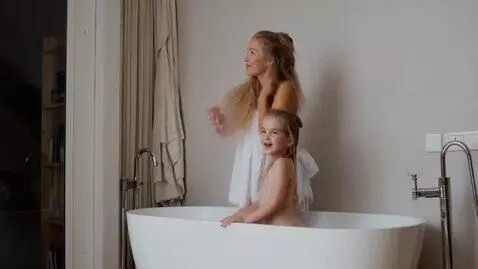 AI Video from prompt: Girl standing in bathtub with daughter