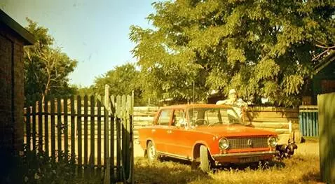 AI Video from prompt: A man poses by his car as a small dog runs past