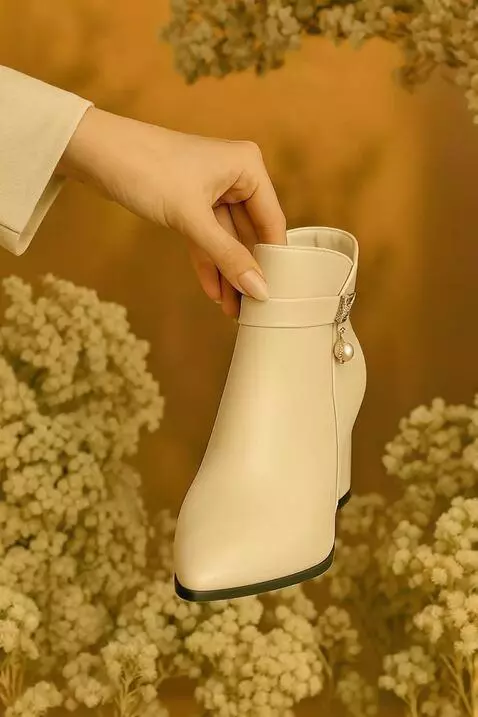 AI Video from prompt: Sebuah sepatu boots hak tinggi warna krem dengan