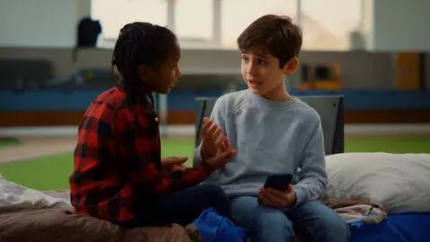 AI Video from prompt: The boy is thinking, sitting on his bed, holding