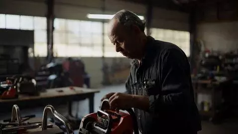 AI Video from prompt: Master repairs chainsaw in garage.