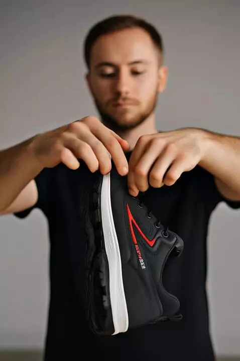 AI Video from prompt: Seorang laki-laki memperlihatkan sepatu hitam sp