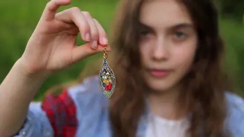 AI Video from prompt: A pretty girl hypnotises veiwer with a pendant