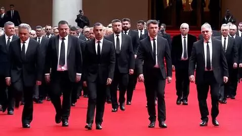 AI Video from prompt: Мужчины в черных костюмах и черных галстуках иду