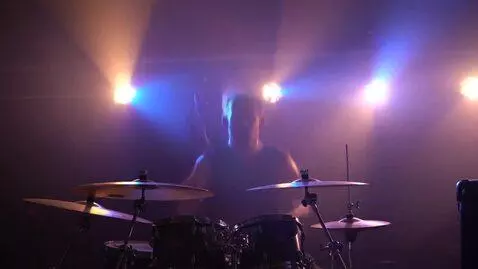 AI Video from prompt: rock club, bright spotlights, fog, smoke, throug