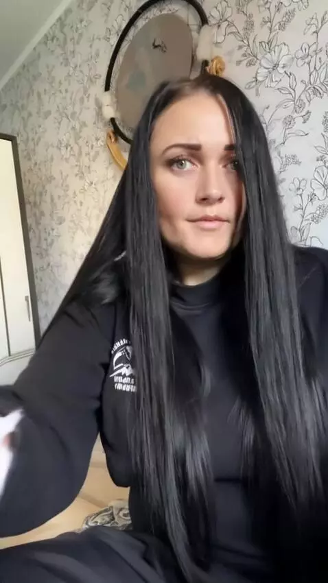 AI Video from prompt: a woman straightens her skirt, from under which 