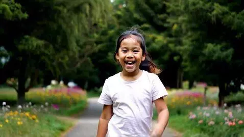 AI Video from prompt: The girl walks straight ahead and smiles and lau