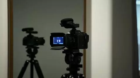 AI Video from prompt: a movie camera on a tripod is facing a mirror. A