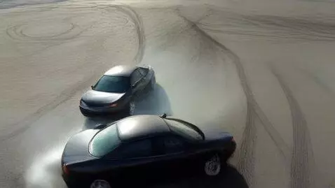 AI Video from prompt: Вид с дрона,две машины едут в дрифте,на ровной п