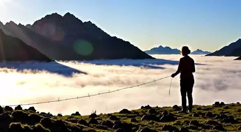 AI Video from prompt: An elderly woman weaves bridges between mountain