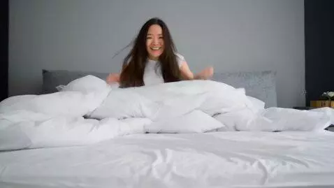 AI Video from prompt: There are many down pillows on the white bed. A 