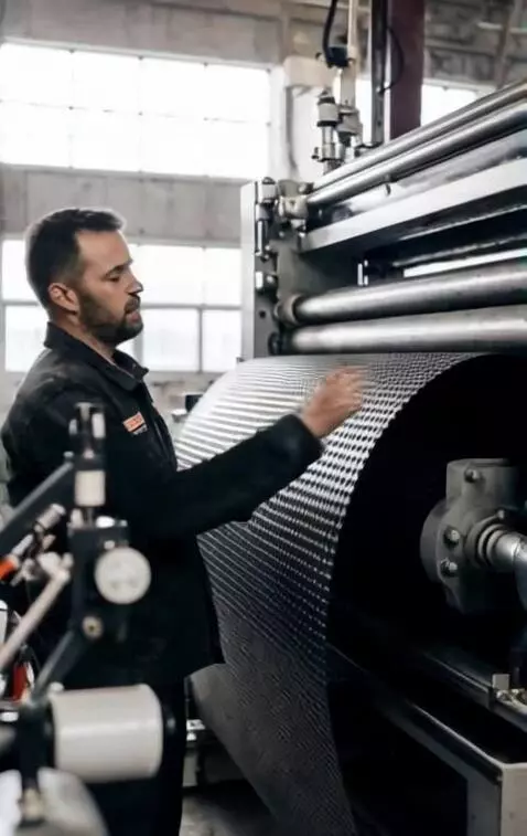 AI Video from prompt: Мужчина касается рулона мембраны на станке и что