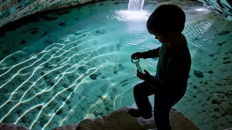 AI Video from prompt: A boy with a glass key stands by a spring that l