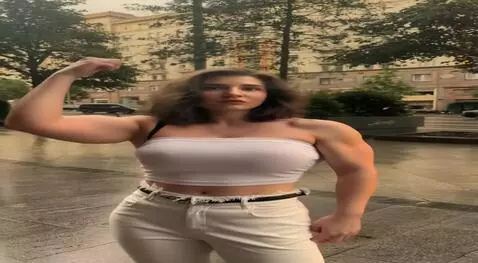 AI Video from prompt: girl confidently shows off her big biceps as she