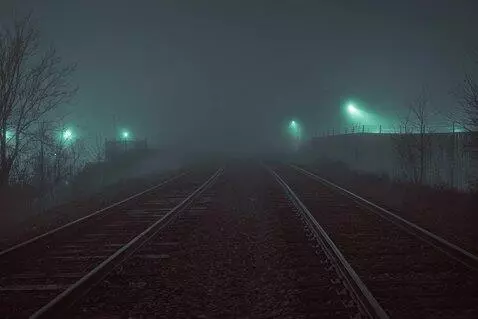 AI Video from prompt: lights flicker in a slow moving fog as a train r
