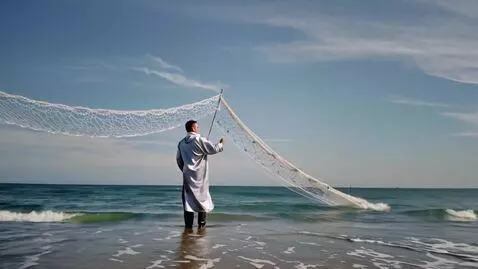 AI Video from prompt: A fisherman in a silver cloak weaves a lace brid