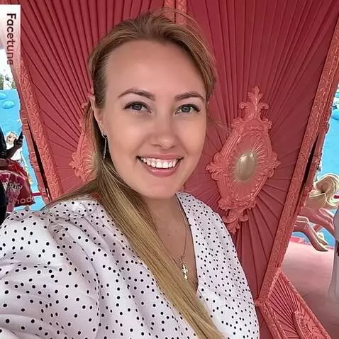 AI Video from prompt: The woman in a white polka-dot blouse smiles bri
