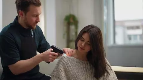 AI Video from prompt: A worker warms up nice woman's back with his gas