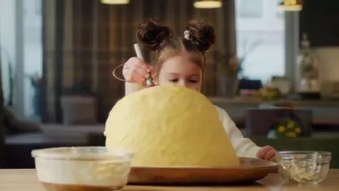 AI Video from prompt: slow motion daughter churning butter.