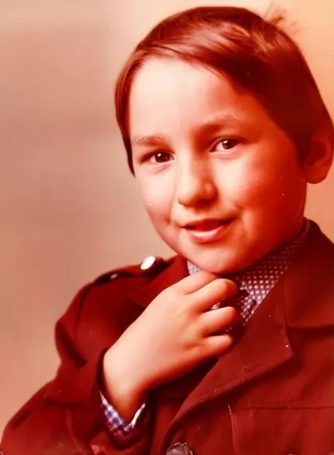 AI Video from prompt: The boy looks at the camera and smiles slightly.