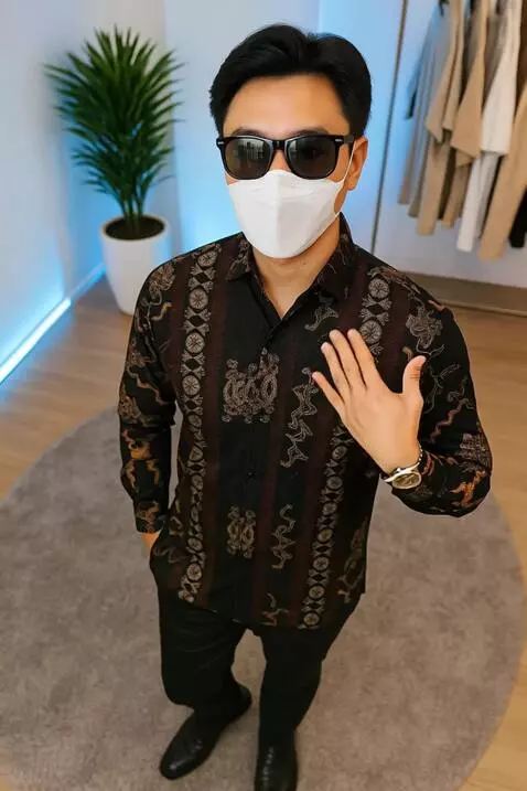 AI Video from prompt: pria ini sedikit manirk kemeja yang dipakainya d