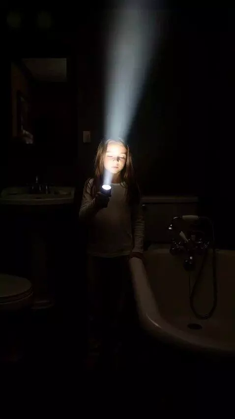 AI Video from prompt: Девушка с фонариком в темной ванной комнате откр