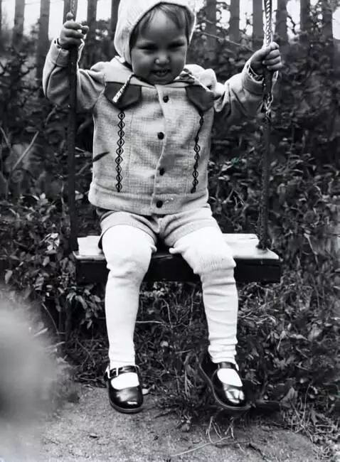 AI Video from prompt: The boy is slowly swinging on the swing and look