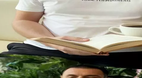 AI Video from prompt: A man is sitting in a modern cafe reading a book