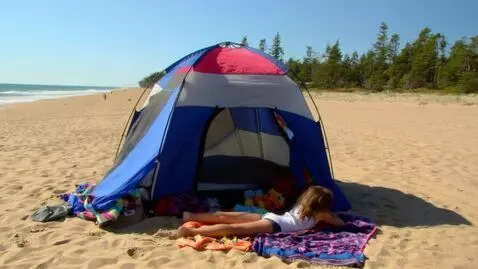 AI Video from prompt: Sunny day at a beach with a girl laying under a 