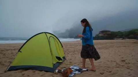 AI Video from prompt: a girl under a tent at the beach and a tsunami c