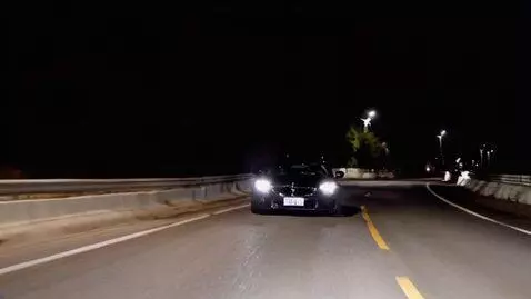 AI Video from prompt: Create a video of a black car speeding down a ni