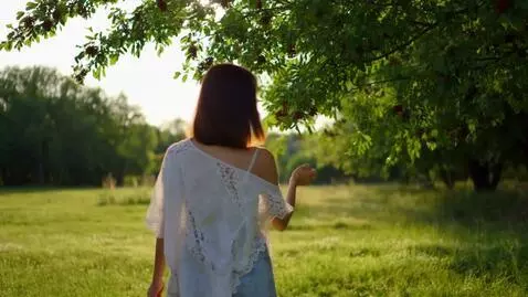 AI Video from prompt: Женщина встает с поля и идет к дереву. У этой же