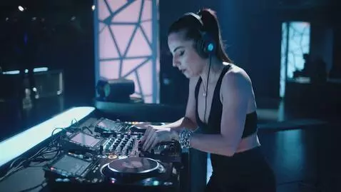 AI Video from prompt: A beautiful female DJ plays mixes and sways to t
