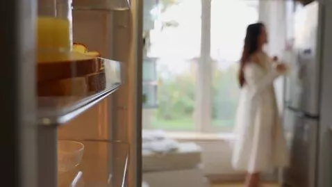 AI Video from prompt: 画面： 柔和而明亮的晨光透过薄纱窗帘，一位精致宝妈起床走向冰箱从冰箱中拿出一片面包片，放入平底锅