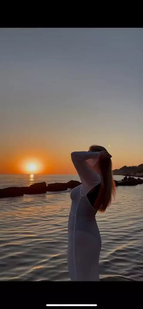 AI Video from prompt: a girl is standing on the beach, posing for the 