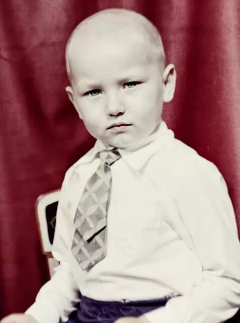 AI Video from prompt: The boy sits quietly and claps his hands slightl