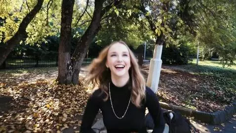 AI Video from prompt: A pretty young woman walks in the park in autumn