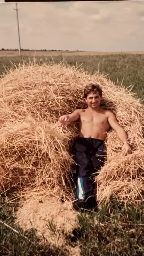 AI Video from prompt: A man lies on the hay. He waves his hand at the 
