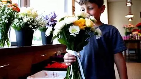 AI Video from prompt: The same person, a boy, walk in flower shop to b