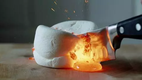 AI Video from prompt: the knife cuts the marshmallow and lava comes ou
