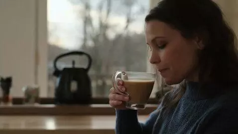 AI Video from prompt: девушка пьет кофе на кухне. за окном осень и иде